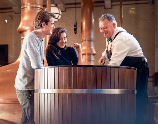 Tre persone sorridenti all'interno della Heineken Experience