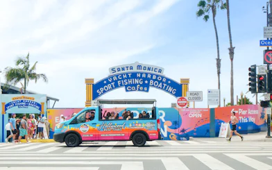Tour bus at Santa Monica Pier entrance on Malibu Beaches and Pacific Coast Highway tour.