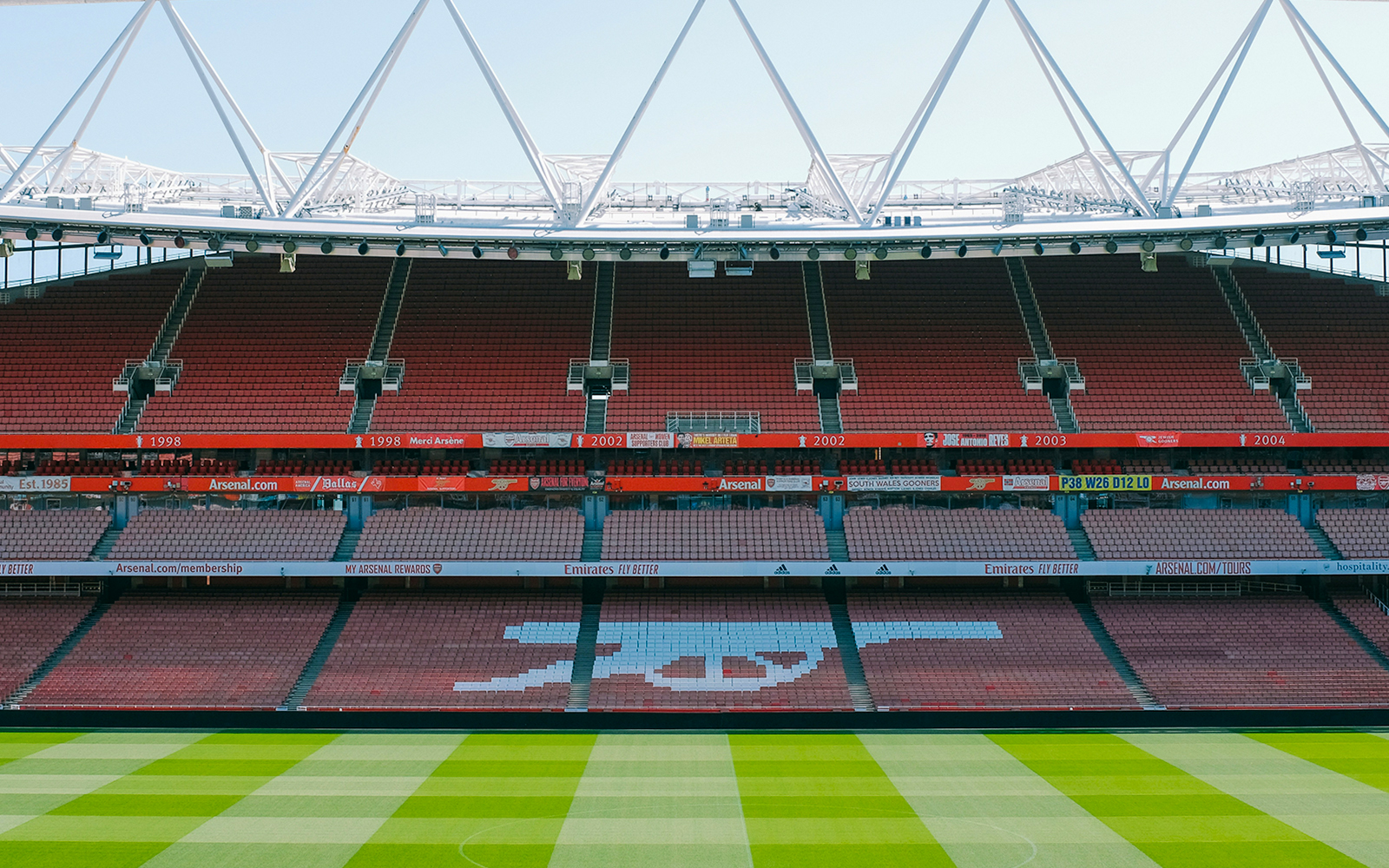 Emirates Stadium seating and field view, showcasing Arsenal's iconic logo.