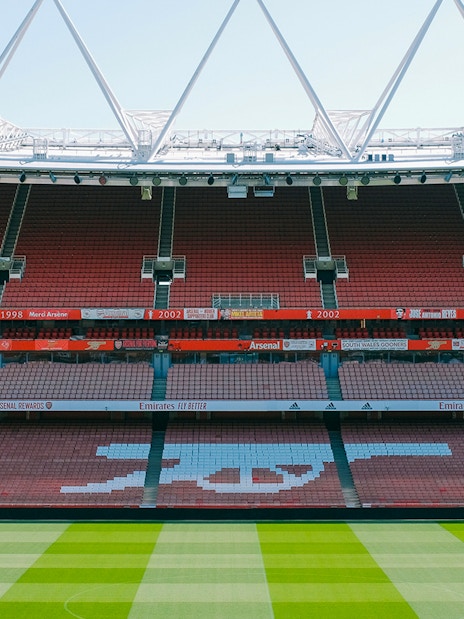 Emirates Stadium seating and field view, showcasing Arsenal's iconic logo.