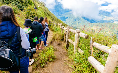 Group trekking on Kew Mae Parn trail, Inthanon National Park, Thailand at sunrise.