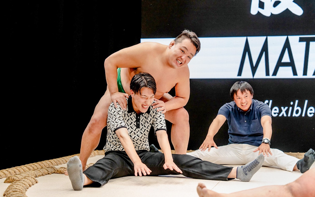 Sumo wrestler interacting with visitors at The Sumo Hall Hirakuza Osaka.