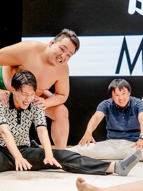 Sumo wrestler interacting with visitors at The Sumo Hall Hirakuza Osaka.