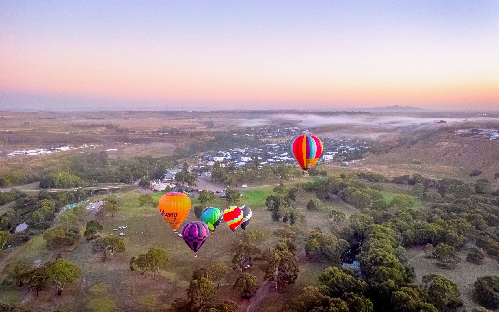 Hot air balloons over Geelong and Bellarine landscape at sunset, Liberty Balloon Flights, Australia.