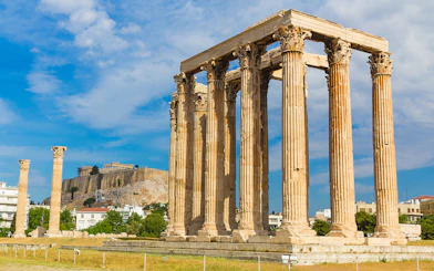 Ancient Temple of Zeus with Acropolis in background, Athens Hop on Hop off Tour.