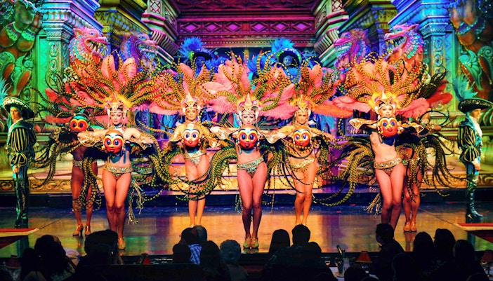 Moulin Rouge Paris cabaret dancers performing with champagne on table.