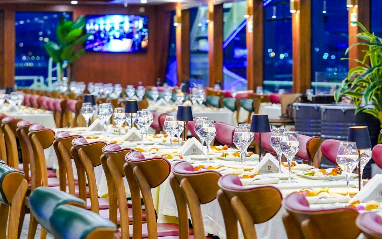 Indoor dining setup on Bosphorus dinner cruise with elegantly set tables.