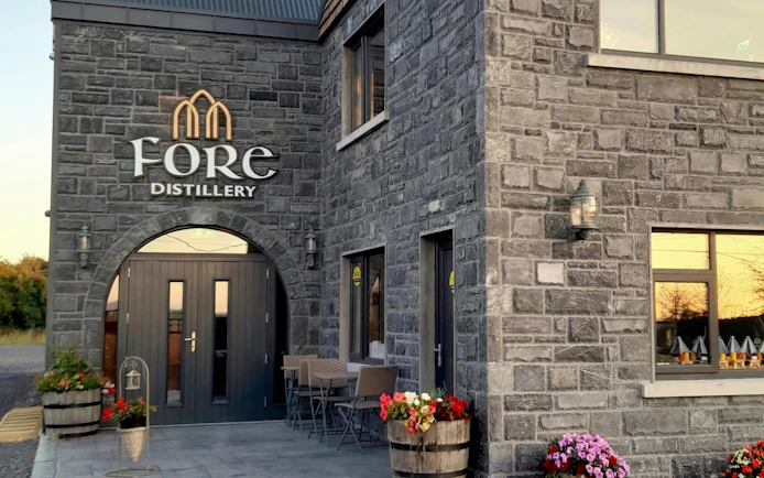 Fore Distillery entrance with stone facade and flower barrels.