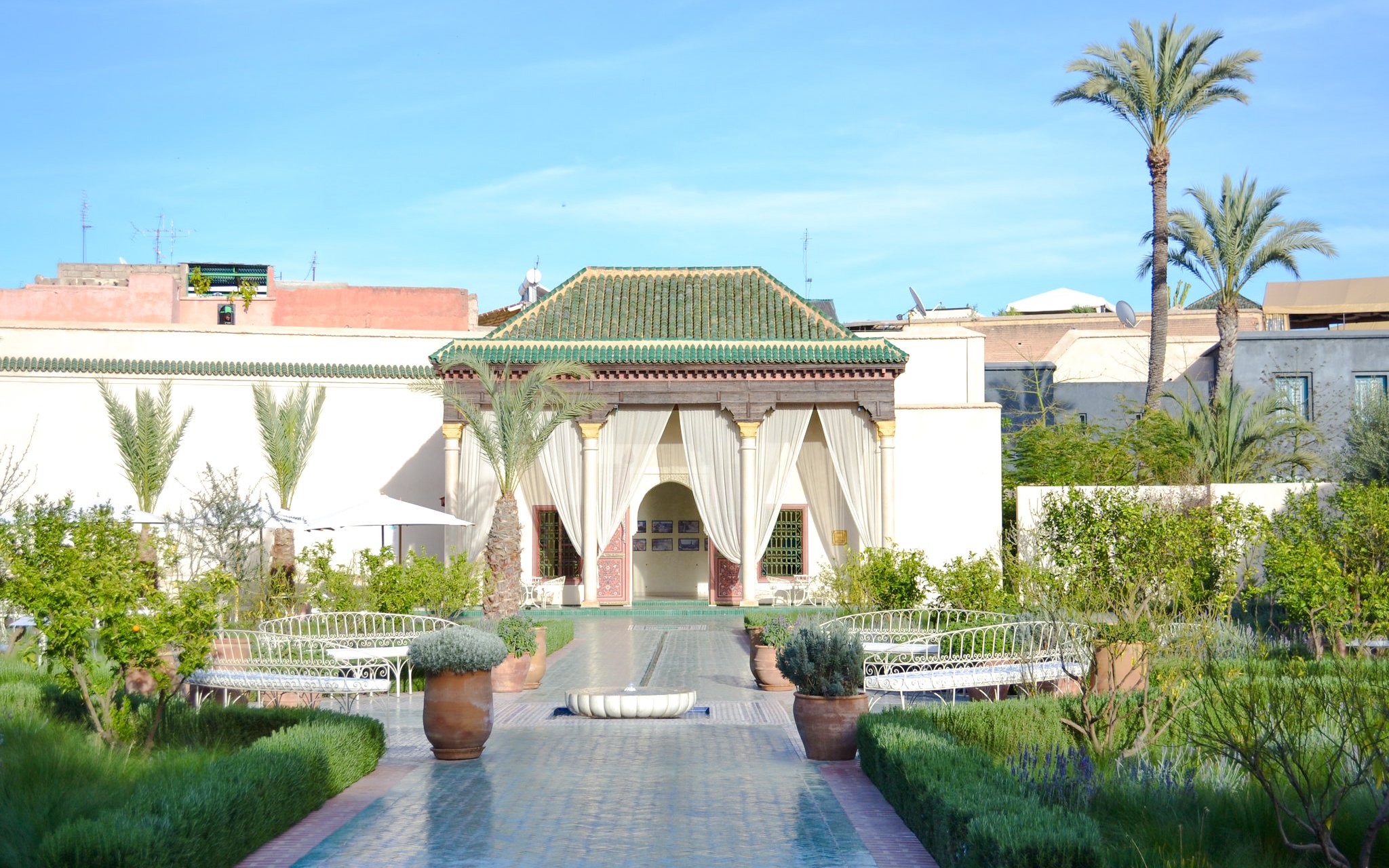 Le Jardin Secret courtyard with greenery and traditional architecture in Marrakech.