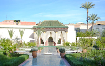 Le Jardin Secret courtyard with greenery and traditional architecture in Marrakech.