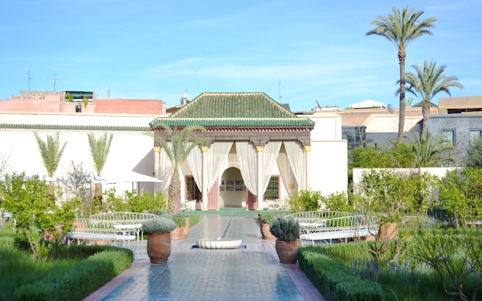 Le Jardin Secret courtyard with greenery and traditional architecture in Marrakech.