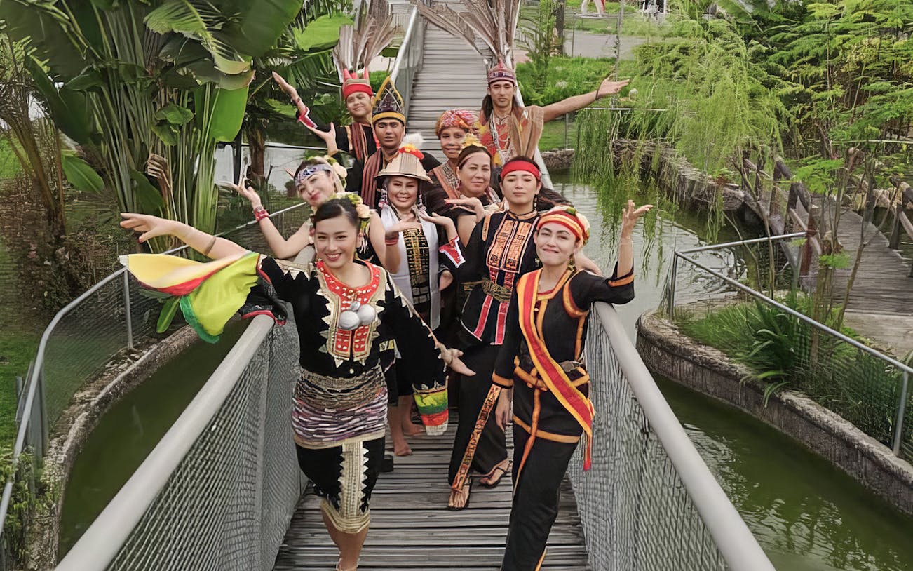 Traditional dancers in colorful attire at Koisaan Cultural Village, Sabah, Malaysia.