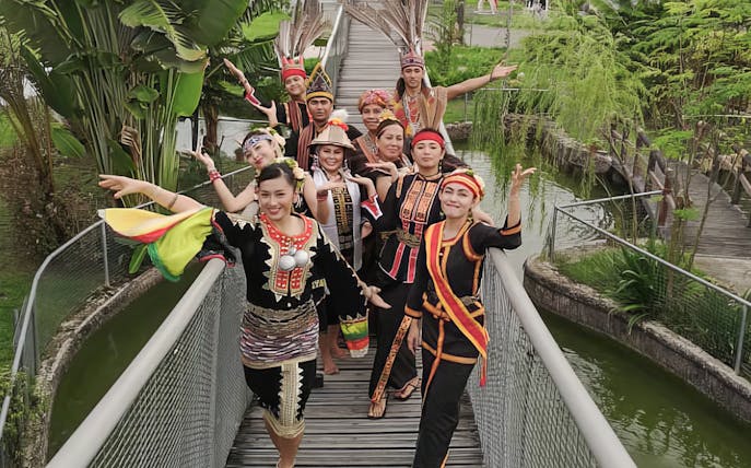 Traditional dancers in colorful attire at Koisaan Cultural Village, Sabah, Malaysia.