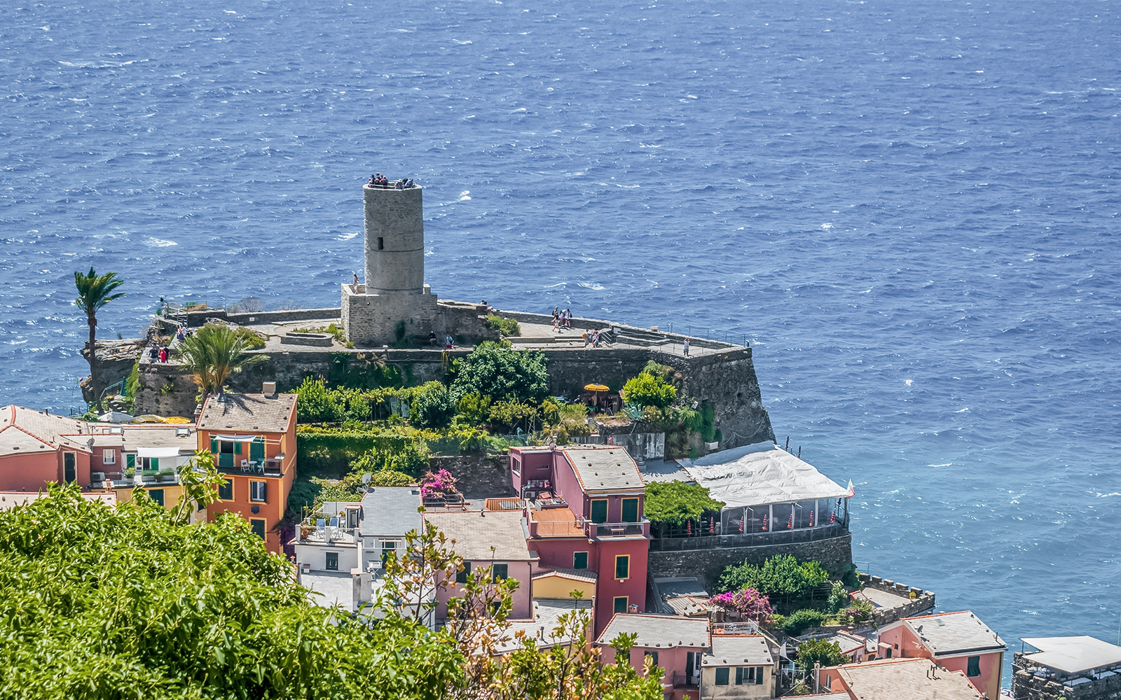 Doria Castle overlooking the sea in Vernazza, Italy, with colorful buildings below.