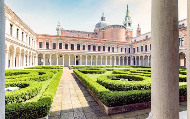 Borges Labyrinth in Venice courtyard with manicured hedges and historic architecture.