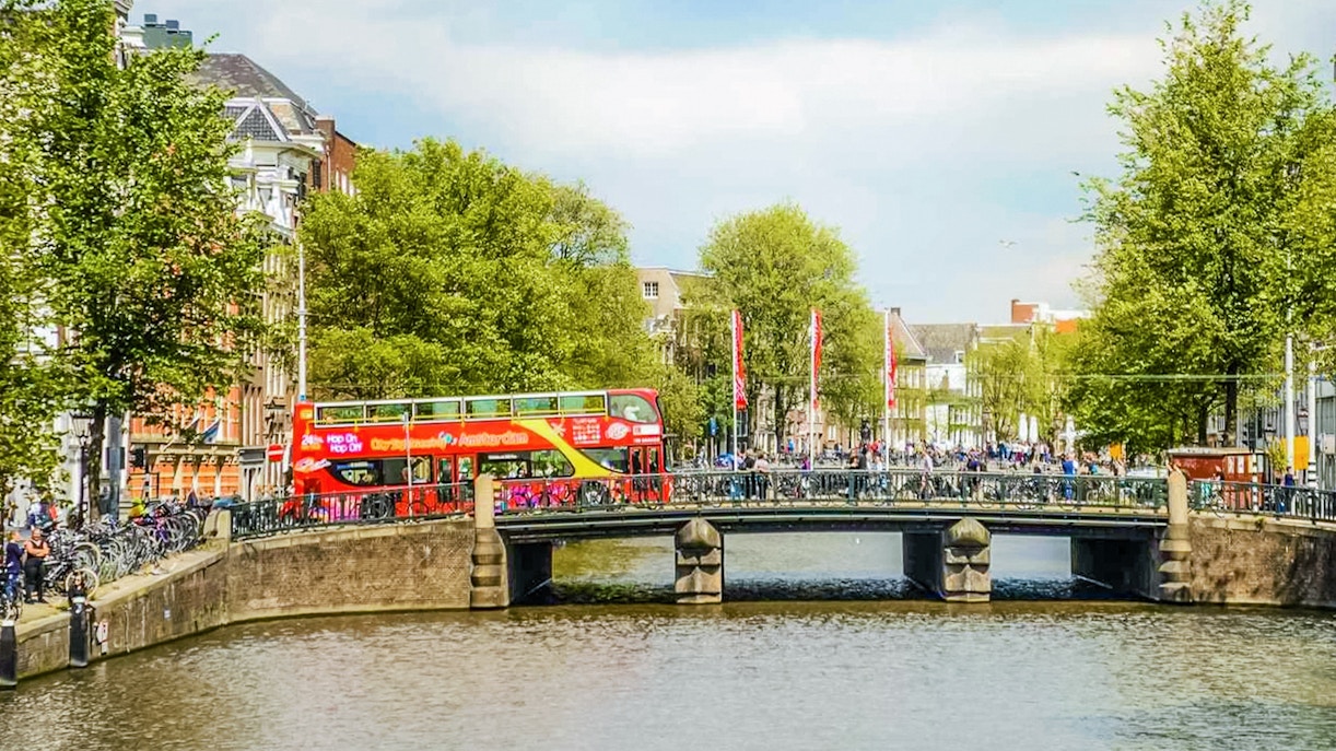 Un ponte di Amsterdam attraversato da un autobus Hop On Hop Off