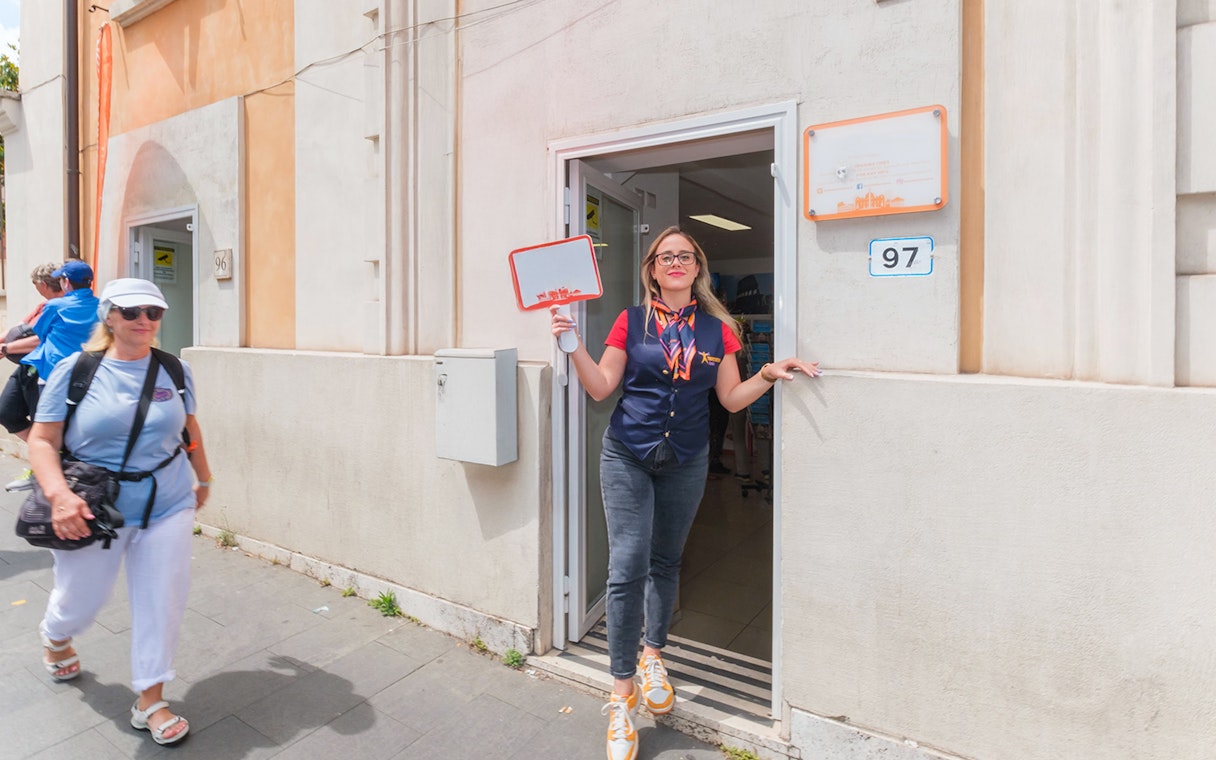 Luggage storage entrance in Rome with staff member welcoming visitors.