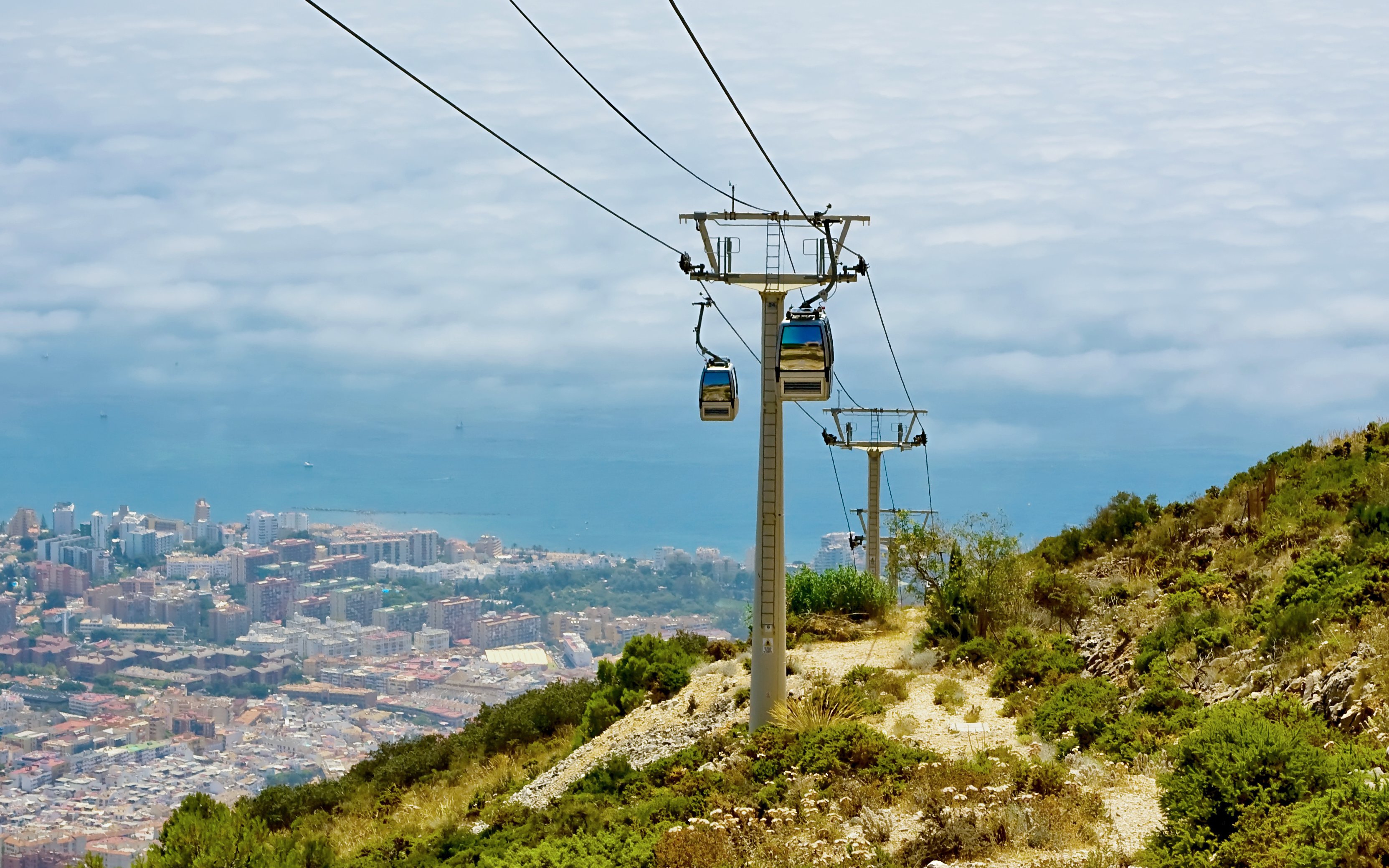 Cable car over Benalmadena coast, Spain, with city and sea view.