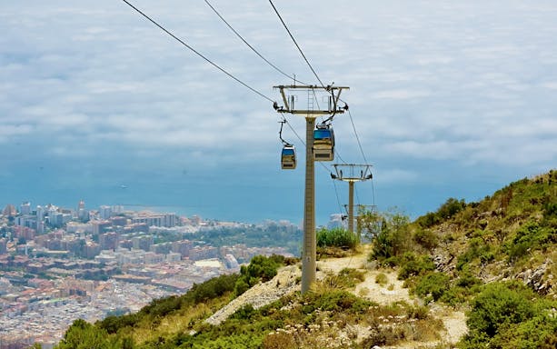 Cable car over Benalmadena coast, Spain, with city and sea view.
