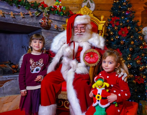 Santa Claus with children at Gardaland Park during Christmas celebration.