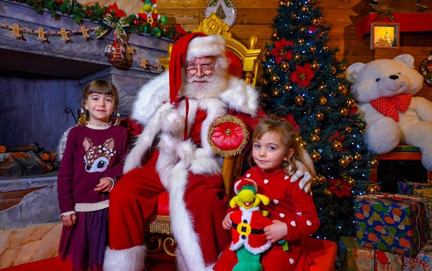 Santa Claus with children at Gardaland Park during Christmas celebration.
