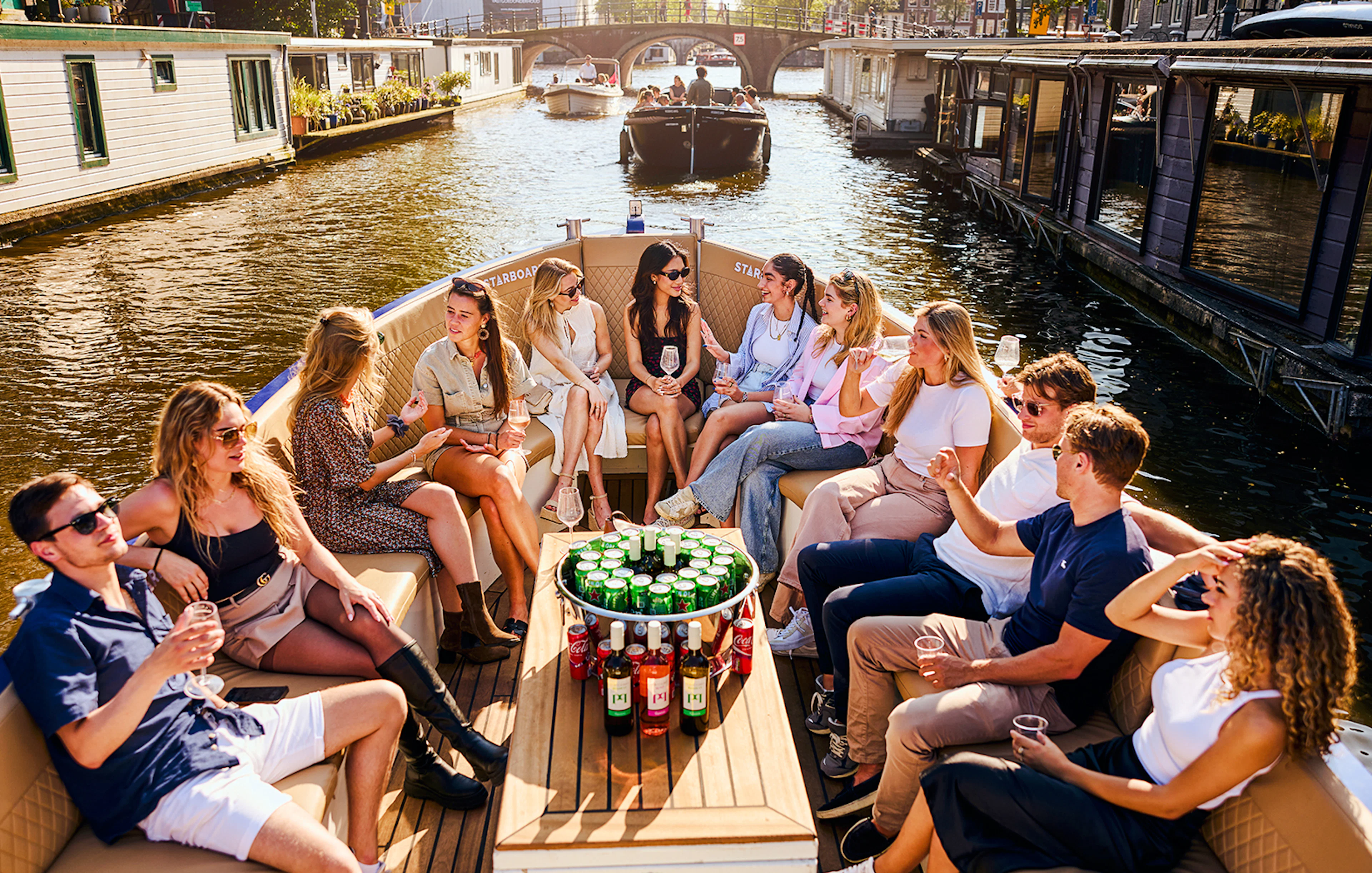 Guests enjoying drinks on a luxury canal cruise in Amsterdam.