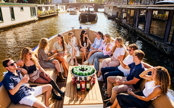 Guests enjoying drinks on a luxury canal cruise in Amsterdam.