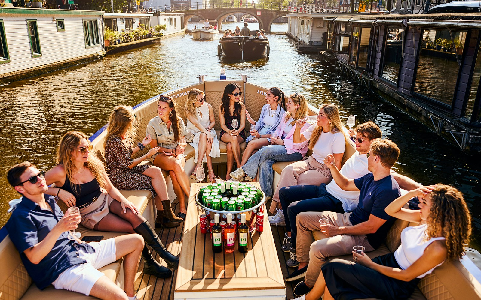 Guests enjoying a Luxury Canal Cruise in Amsterdam with views of historic canal houses.
