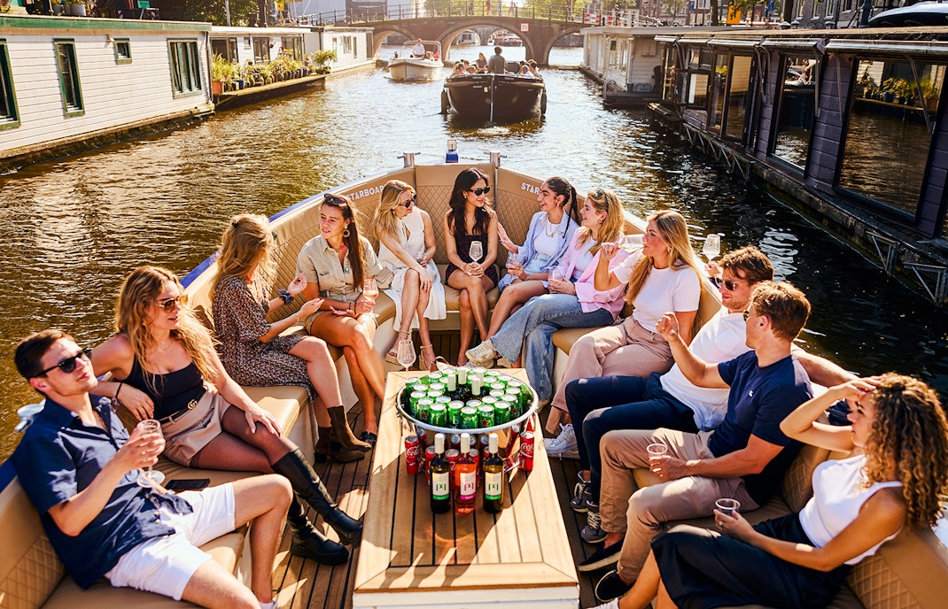 Guests enjoying drinks on a luxury canal cruise in Amsterdam.