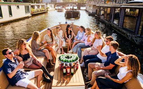 Guests enjoying drinks on a luxury canal cruise in Amsterdam.