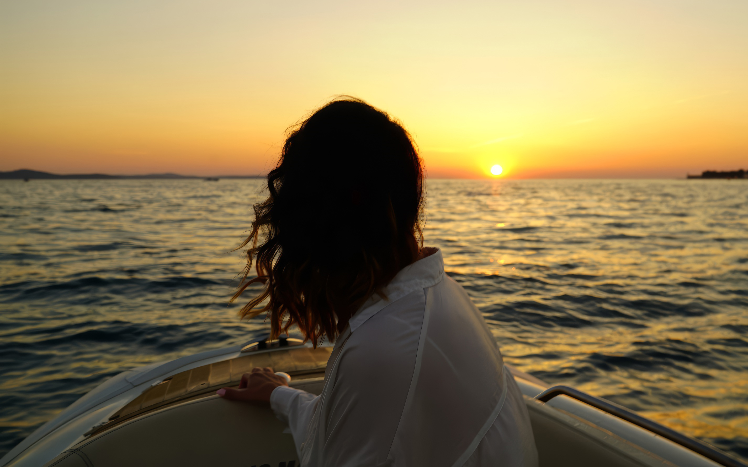 Person on a boat enjoying a sunset cruise near Zadar with sparkling wine.