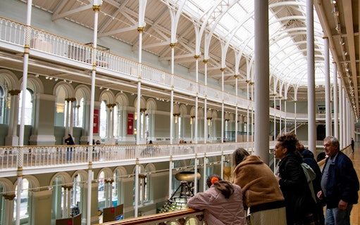 Visitors exploring the interior of the National Museum of Scotland in Edinburgh.