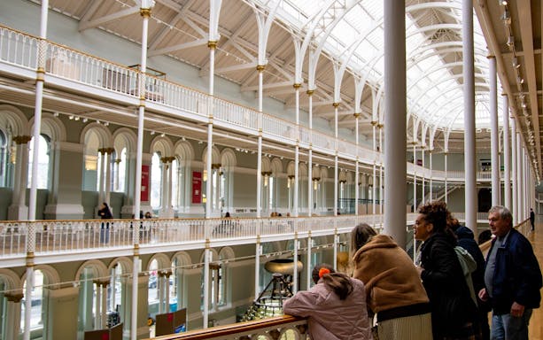 Visitors exploring the interior of the National Museum of Scotland in Edinburgh.