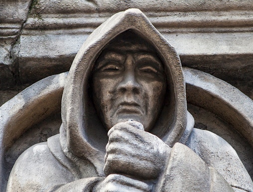 Stone statue of a hooded figure at London Dungeon, London.