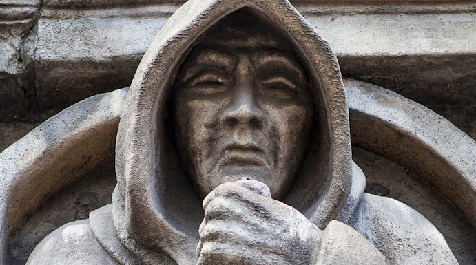 Stone statue of a hooded figure at London Dungeon, London.