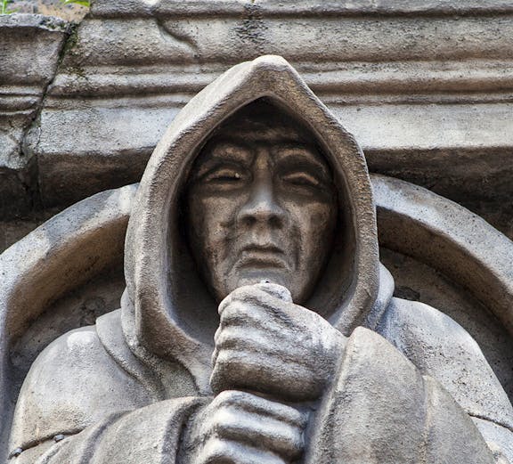 Stone statue of a hooded figure at London Dungeon, London.