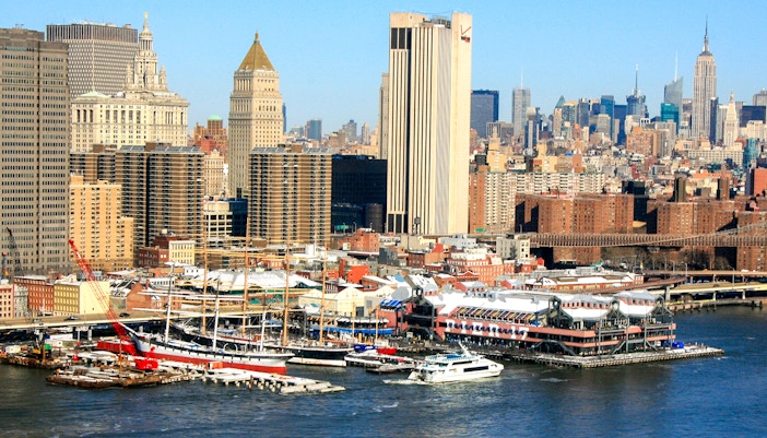 Tourists exploring the vibrant South Street Seaport district in New York, with its historic buildings and bustling waterfront