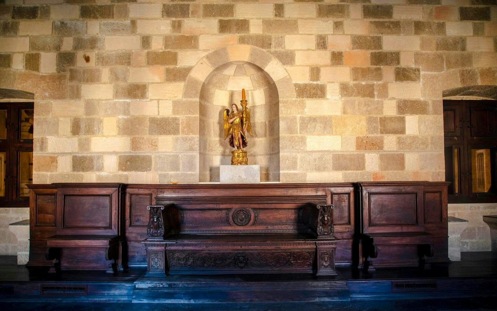 Wooden bench and statue inside Palace of the Grand Master of the Knights of Rhodes.