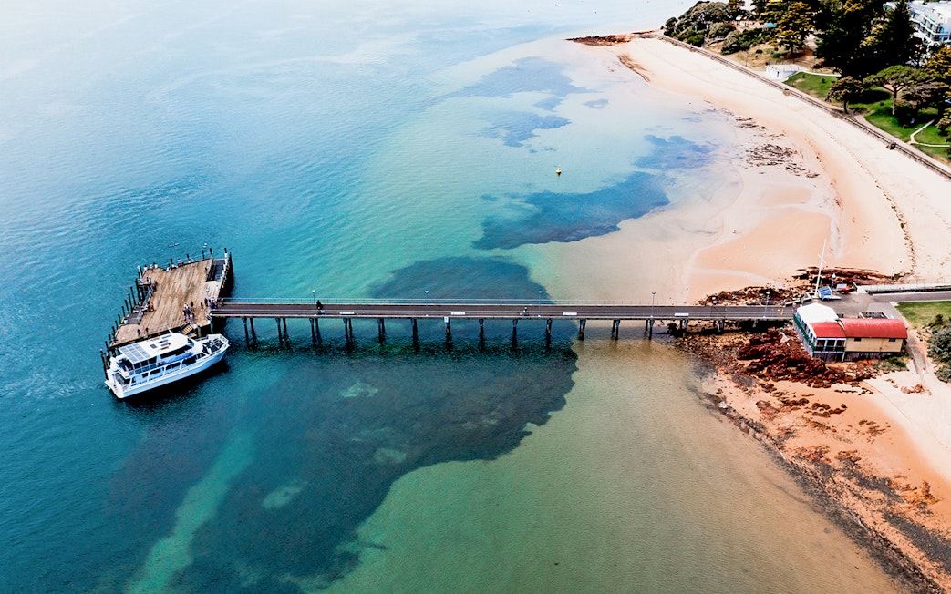 Phillip Island pier with cruise boat docked for seal watching tour.