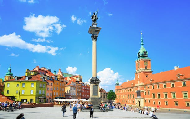Castle Square in Warsaw with Sigismund's Column and colorful historic buildings.