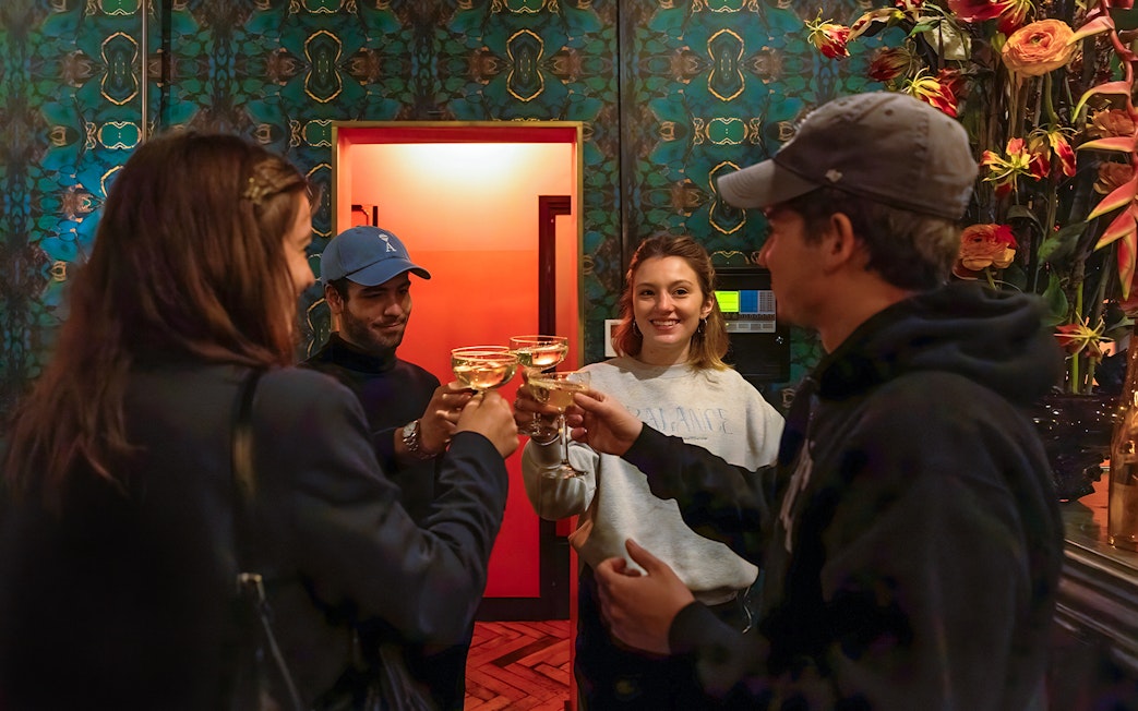 Visitors toasting at Tour de BonTon with floral decor in the background.