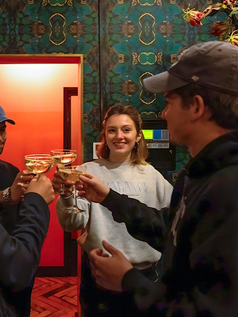 Visitors toasting at Tour de BonTon with floral decor in the background.