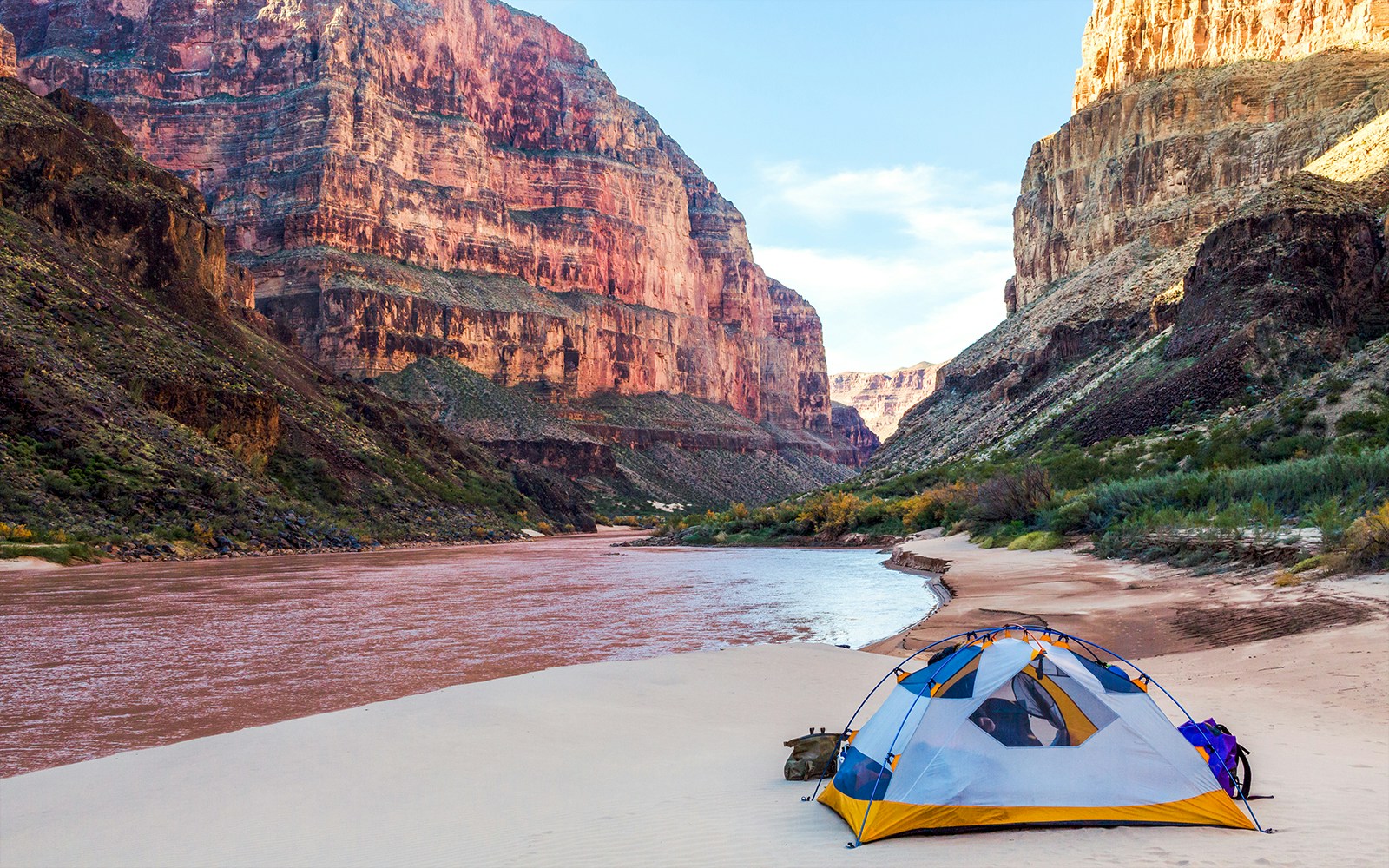 Open tent with view of Grand Canyon cliffs and sky.