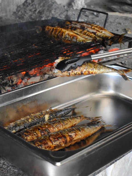 Grilled fish being prepared on an open flame during Blue Lagoon and 3 Island tour from Split.