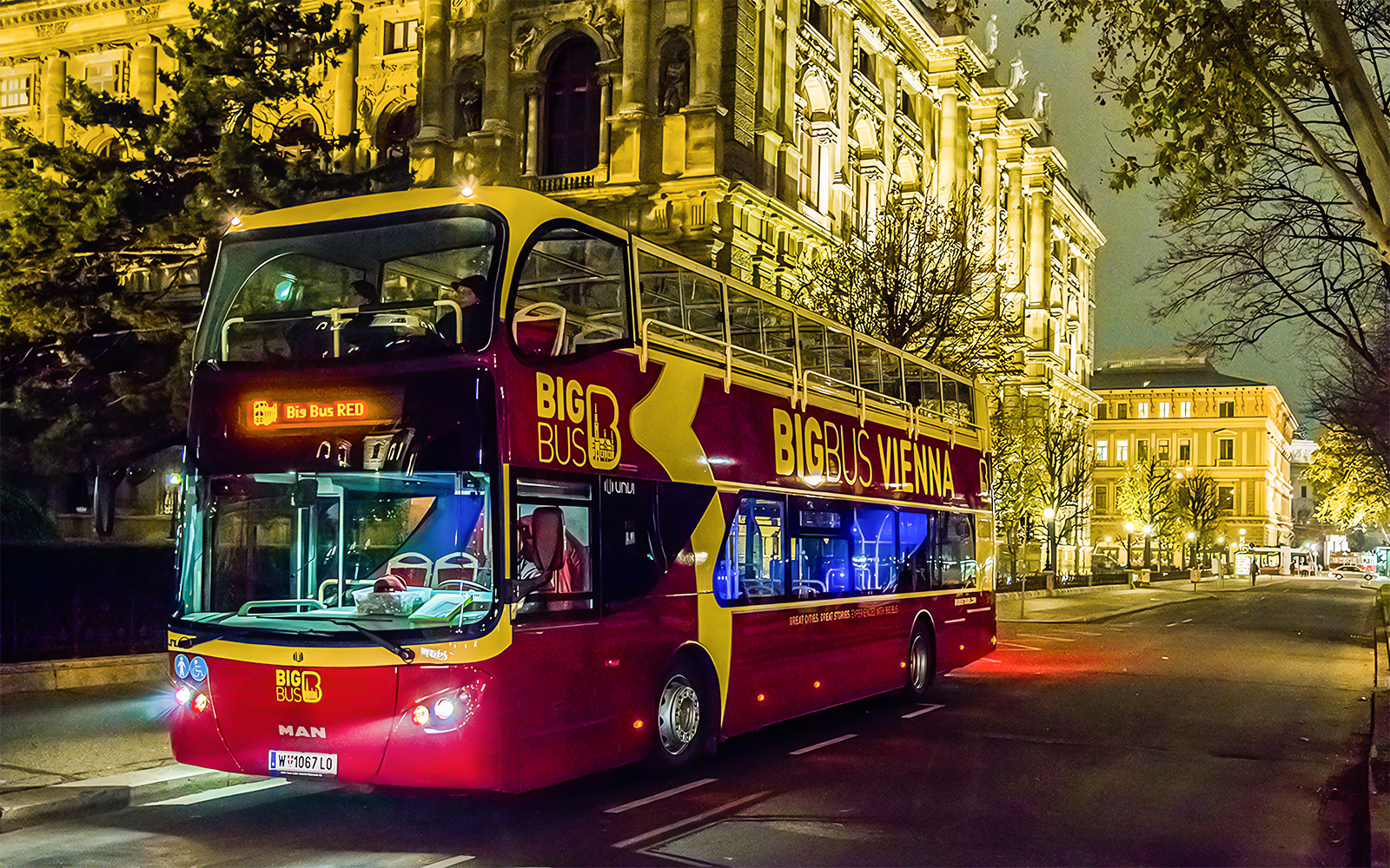 Vienna Big Bus Tour with a view of historic buildings and city streets at night.