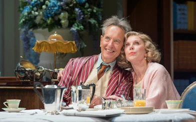 Actors in a scene from "Hay Fever" at West End, seated at a dining table with tea set.