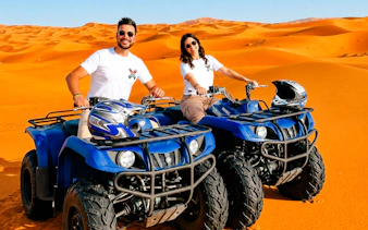 ATV riders in Abu Dhabi desert during safari tour.