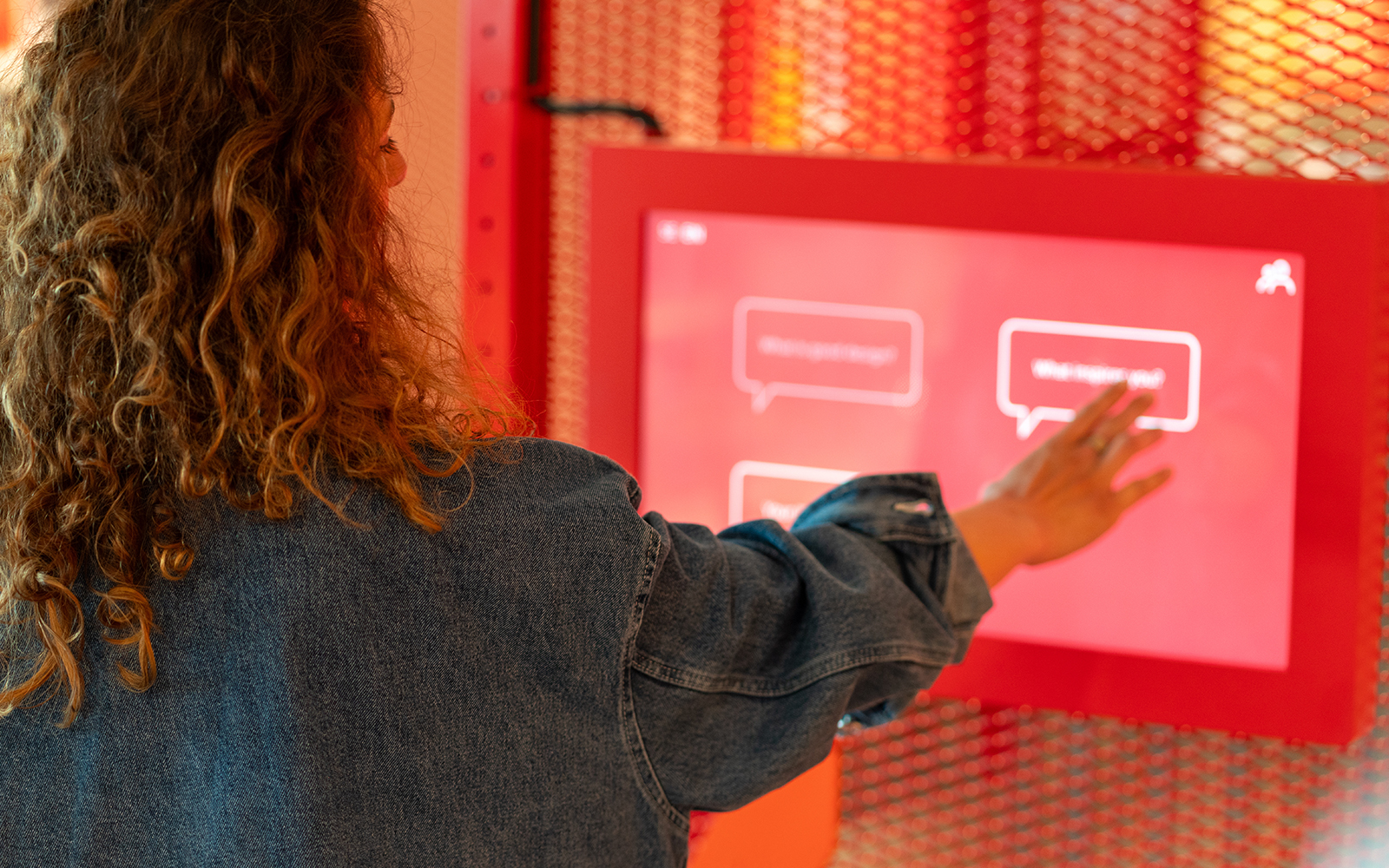 Curly hair woman using touch screen at the exhibition