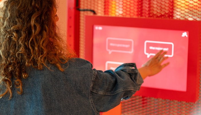Curly hair woman using touch screen at the exhibition