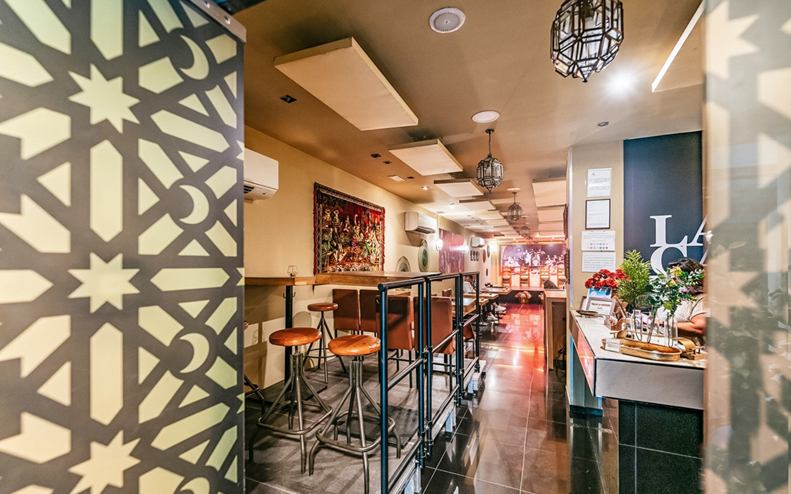 Flamenco show venue interior with bar seating and decorative wall panel.